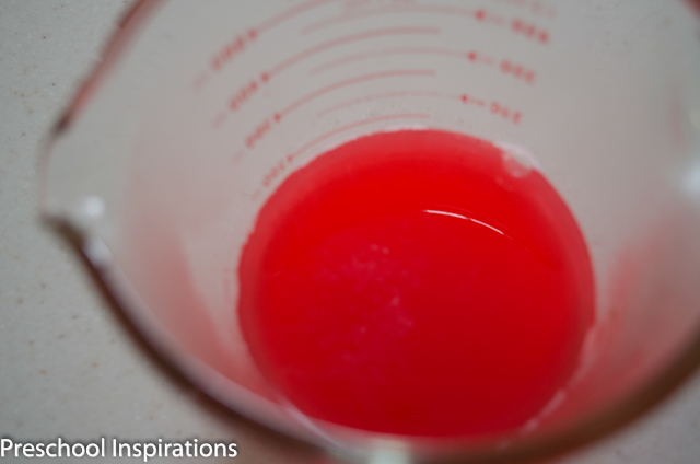 red liquid watercolor in a measuring cup