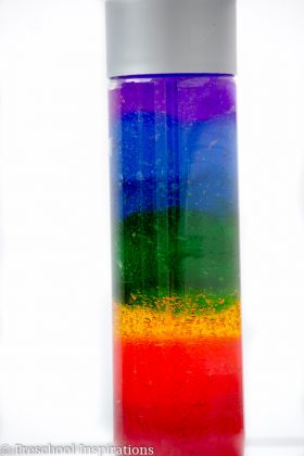 Sensory bottle with rainbow colored layers.