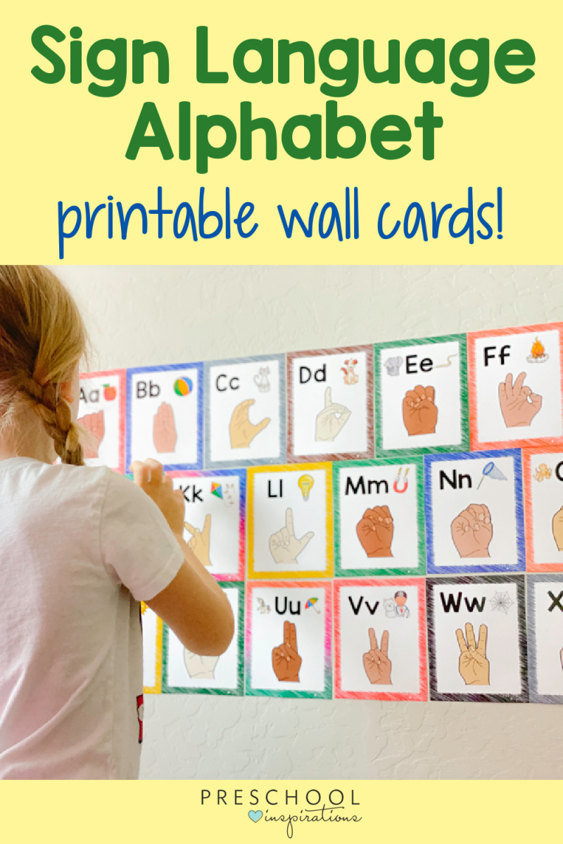 girl standing in front of printable alphabet wall cards with the text, 'sign language alphabet printable wall cards'