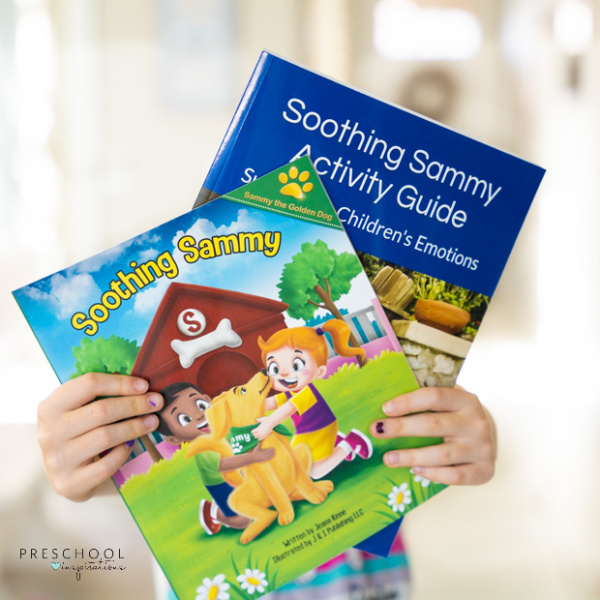 a child's handing holding up two Soothing Sammy books